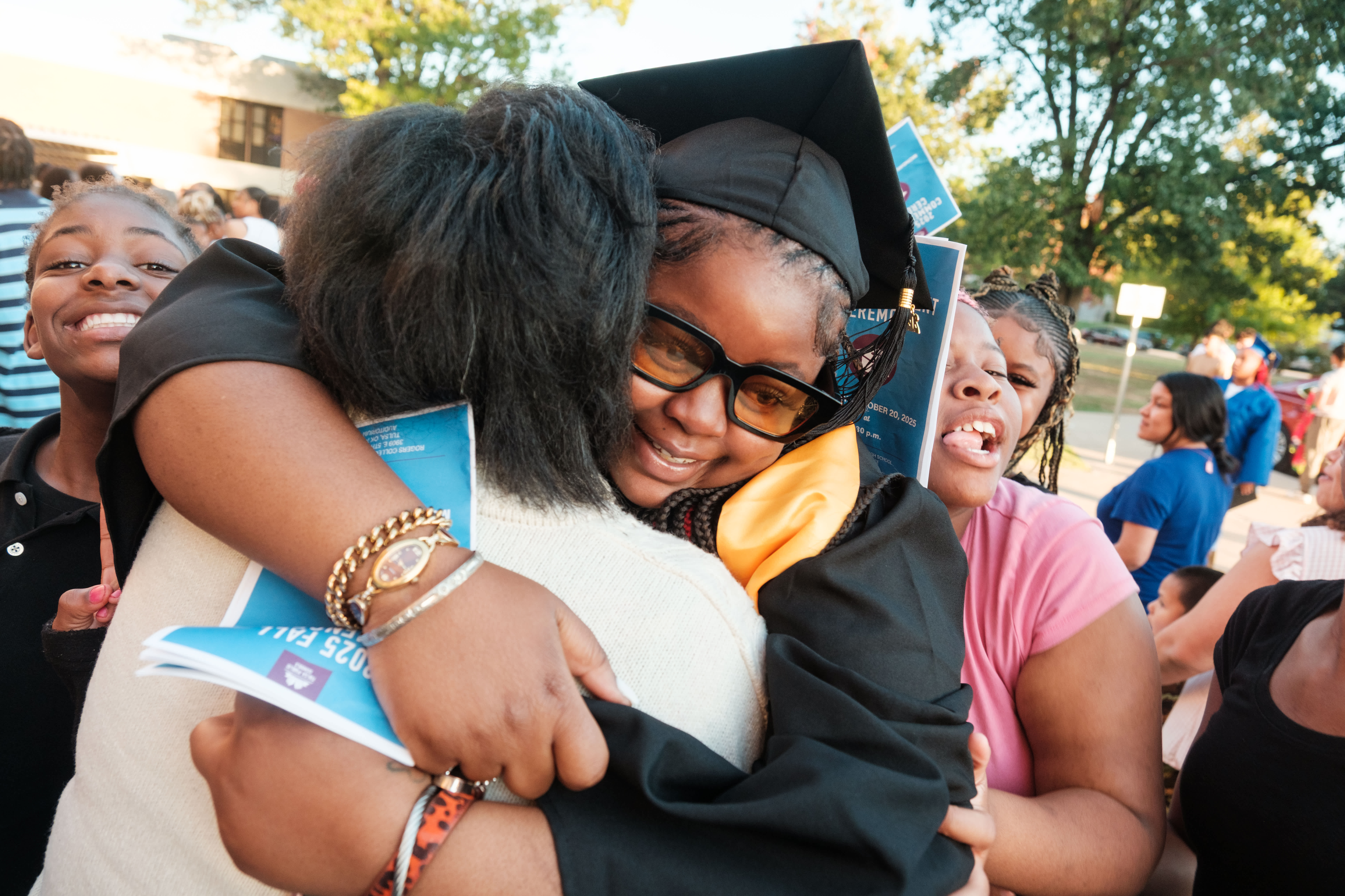 a student hugs her family at graduation