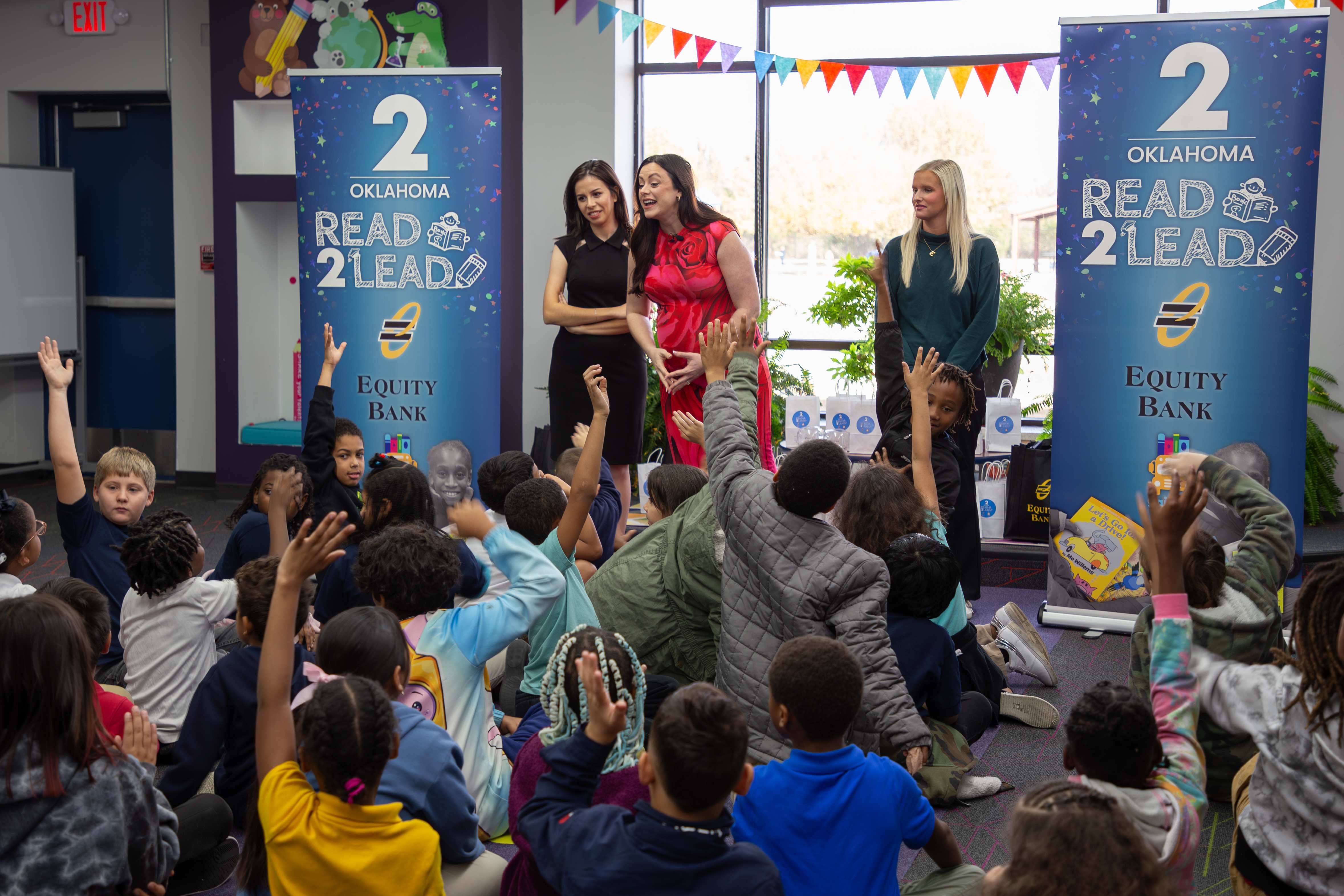 students raise their hands while in a Read 2 Lead program