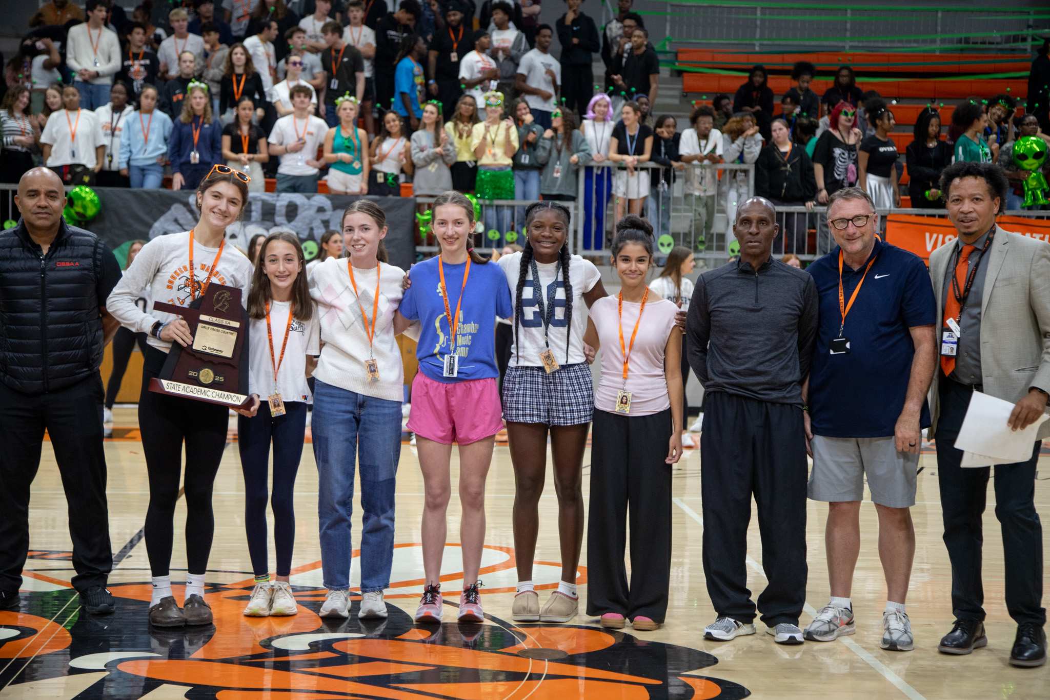 the cross country team poses with their academic all state trophy